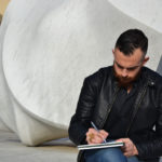 “Colori oltre la materia”: le sfumature dell’arte attraverso i quadri di un giovane ragazzo di Carbonia Giuseppe Tuveri disegna. Nello sfondo Frammento di Vuoto.